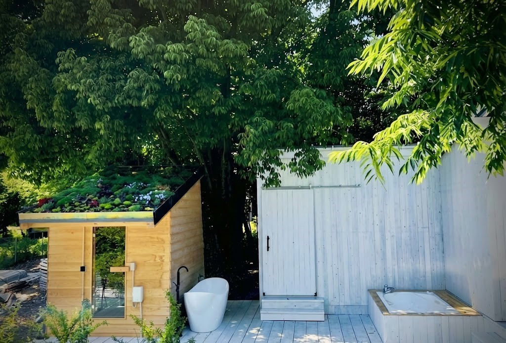 滋賀県大津市の貸切BBQサウナ「スター★ハウス」。森の中の白いウッドデッキにある草屋根サウナ、白い水風呂、シャワー更衣室、露天ジャグジー、BBQ施設の全景。